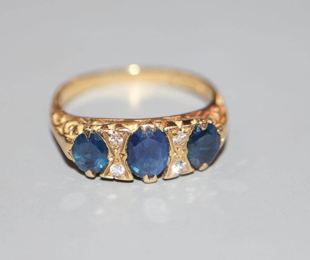 A 1970s Victorian style 18ct gold and three stone sapphire and diamond chip set dress ring, size L, gross 4.3 grams.
